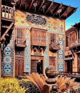 Traditional Baghdad building with decorative tiles and wooden balconies in sunny courtyard