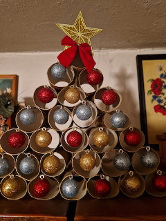 Triangular Christmas tree made of colorful bottle caps with gold star on top