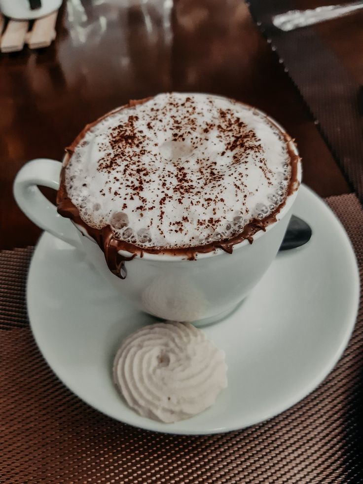 Steaming coffee cup with scattered roasted coffee beans