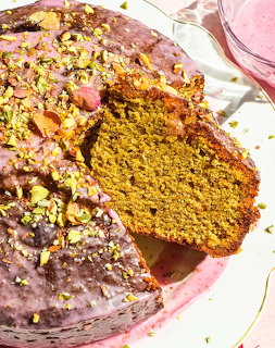 Sliced pistachio lime cake with pink icing and chopped pistachios on top