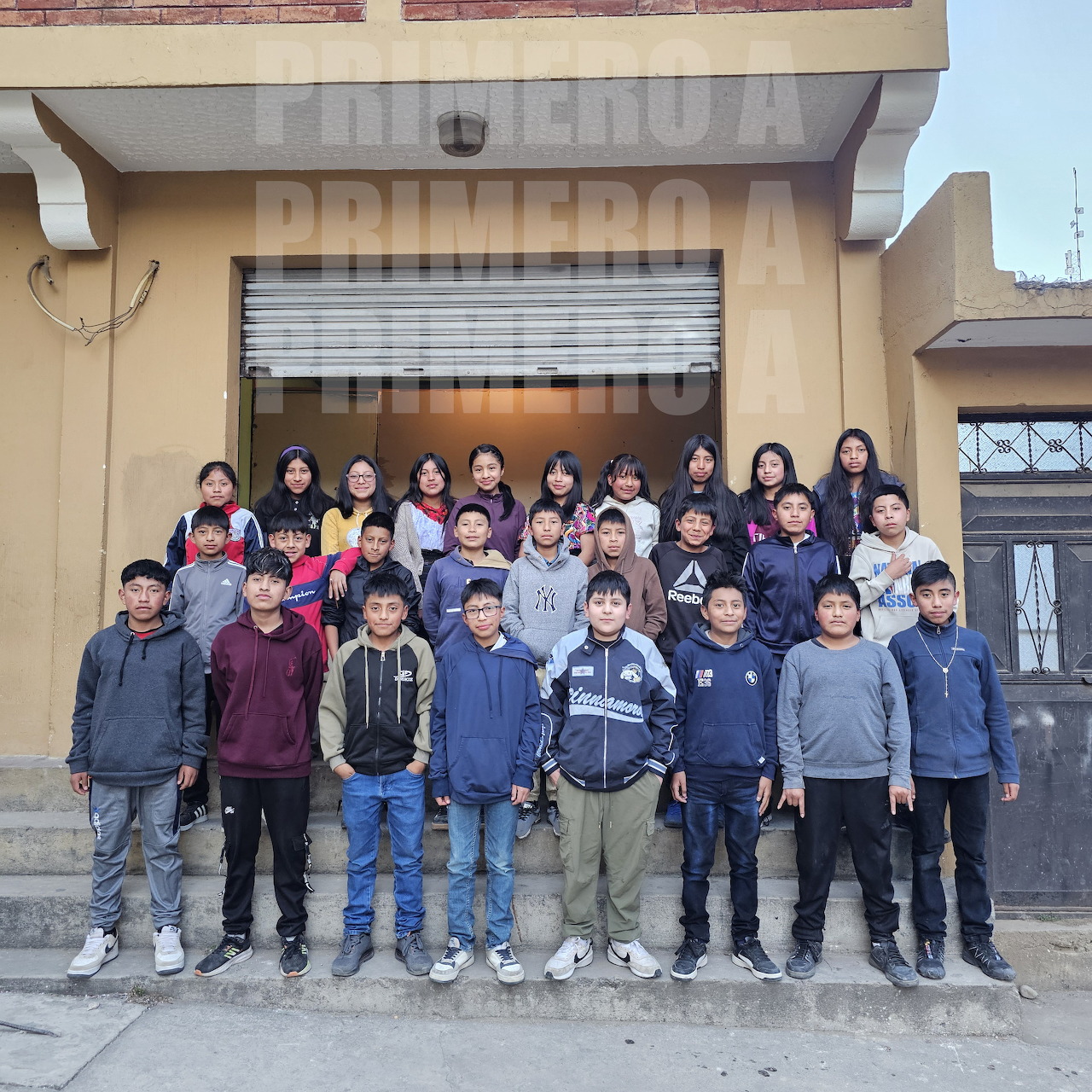Group of students standing on steps in front of a building entrance