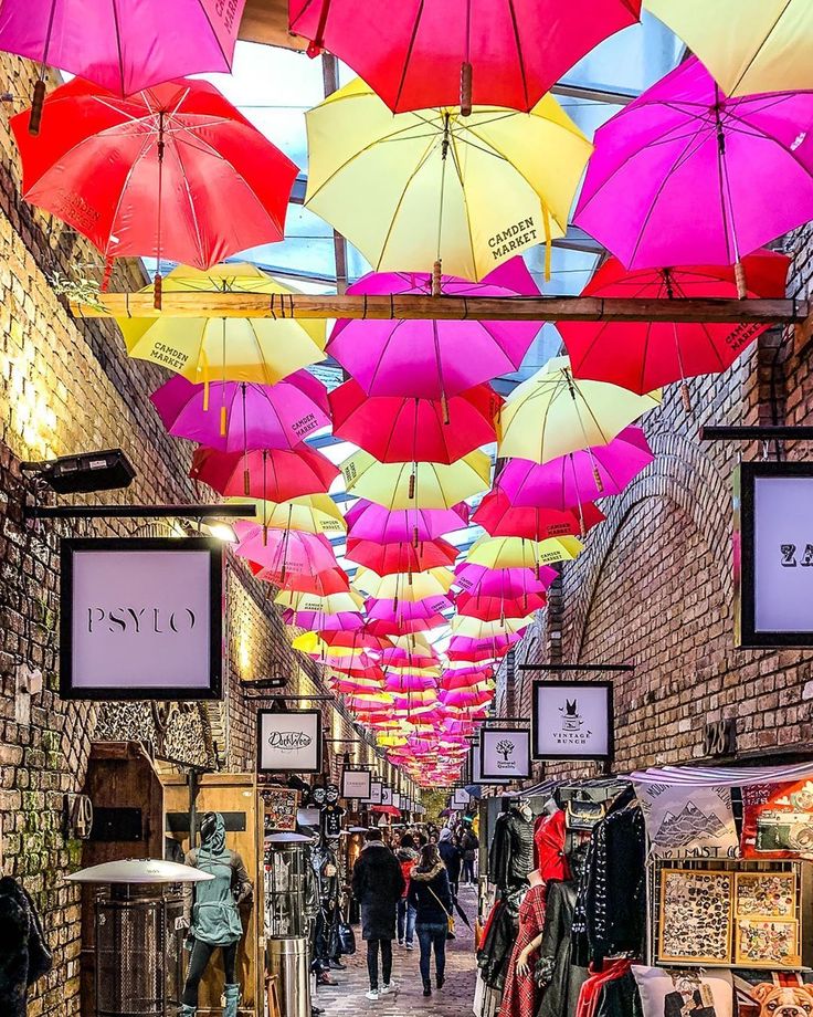 Colorful umbrellas hanging above Camden Market street with shoppers below