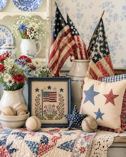 Vintage patriotic decor with American flags, star pillows, flowers, and quilted fabric on a table
