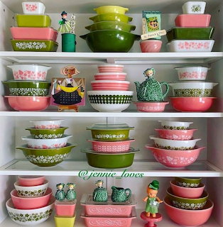 Shelves filled with colorful vintage Pyrex bowls in pink, green, and patterned designs