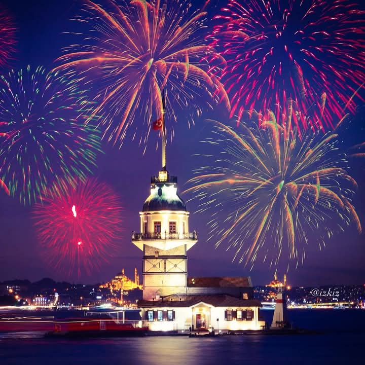 Maiden's Tower in Istanbul at night with colorful fireworks over the water