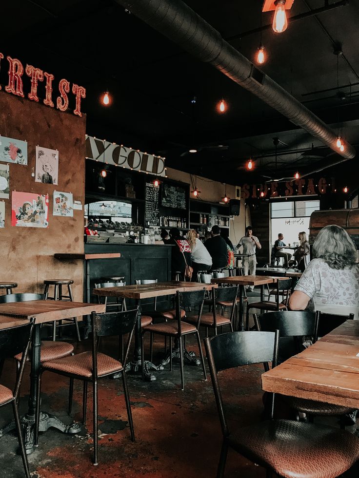 Interior of a cozy cafe with wooden tables, pendant lights and a counter