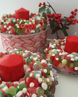 Christmas themed chocolate cakes decorated with colorful candies, red candles and holly berries