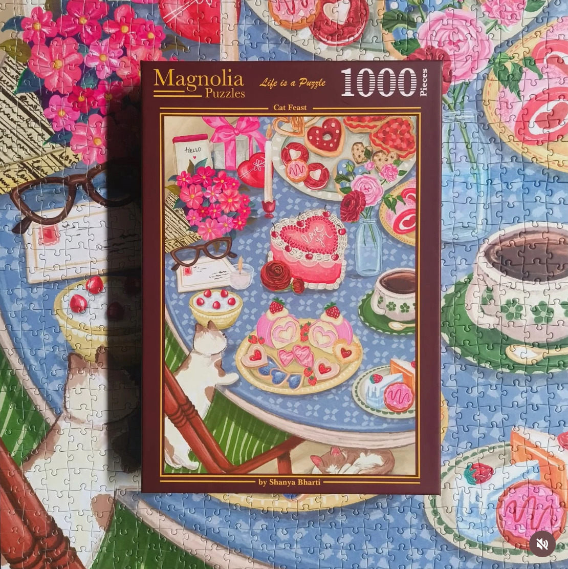 Puzzle box on a matching jigsaw image with teacups, cakes, pastries, and pink flowers