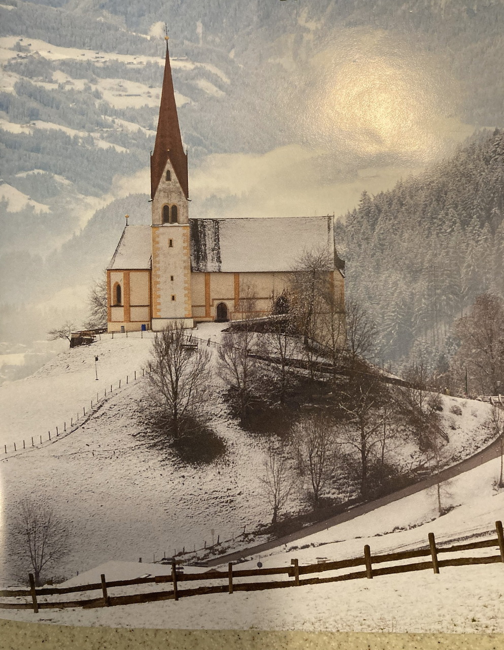 Small church in a snowy winter landscape with bare trees