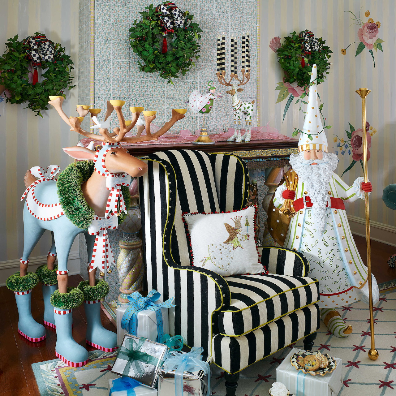 Whimsical Christmas display with decorative reindeer, striped chair, angel figure, wreaths, and holiday ornaments