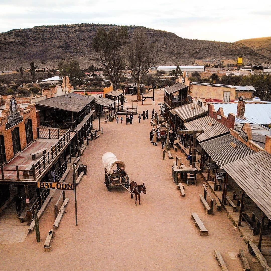 Overhead view of Old West town film set with wooden storefronts, wagons, and people in Durango, Mexico