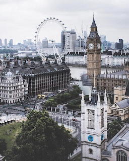 Aerial cityscape showing Big Ben clock tower, London Eye ferris wheel, and Thames River in London