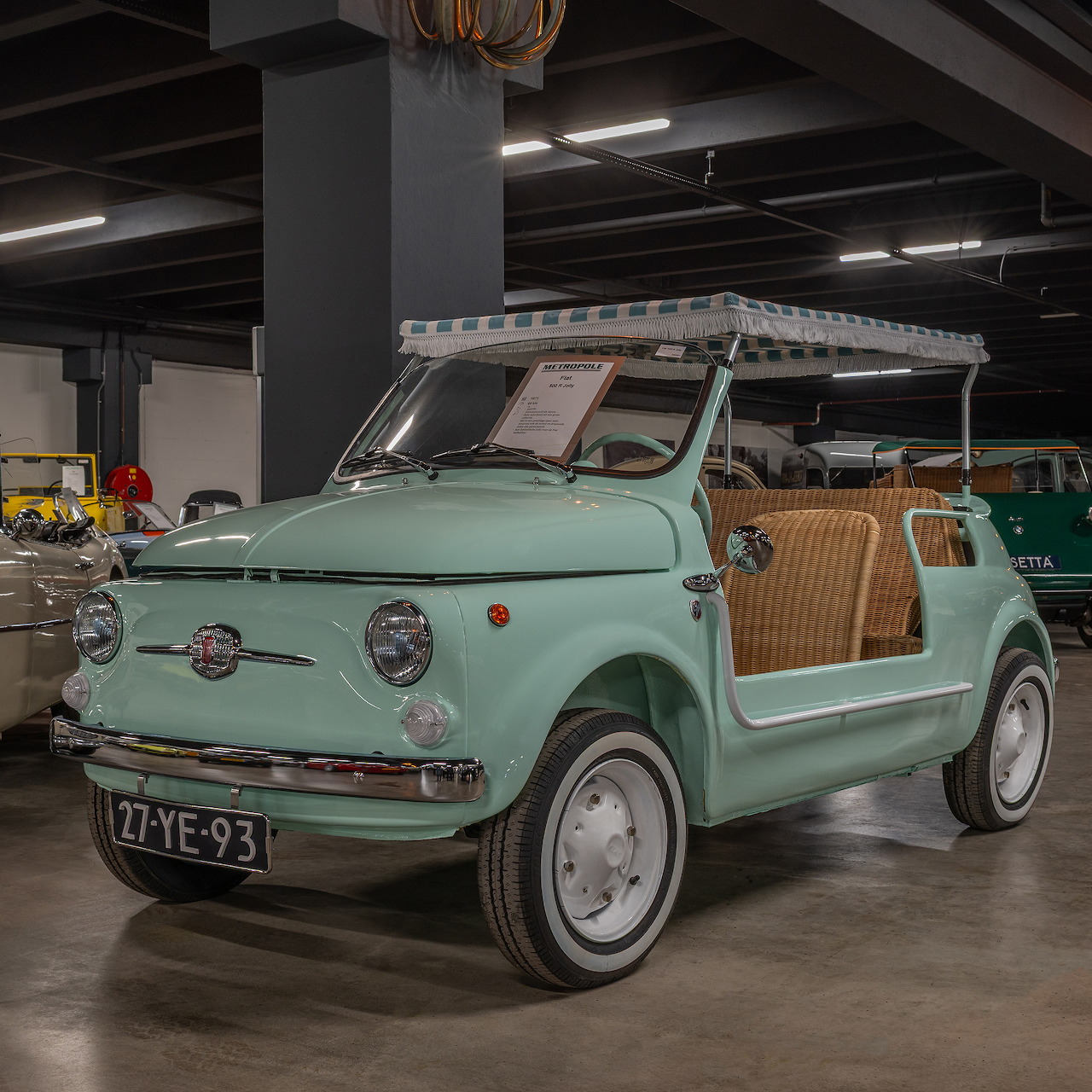 Mint green 1973 FIAT 500 R Jolly beach car with wicker seats displayed indoors