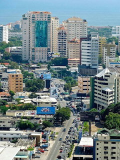 Aerial view of city with tall buildings, streets, and traffic