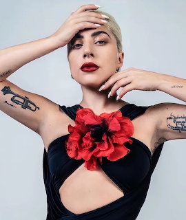 Lady Gaga portrait with blonde hair, red lipstick, black outfit with red flower detail