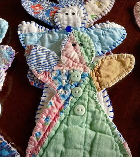 Quilted fabric angel with patchwork design in pastel colors and button details