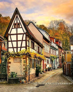 Cobblestone street with traditional half-timbered houses in Weinheim, Germany at sunset