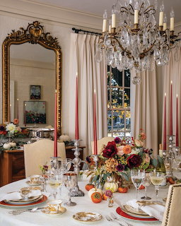 Elegant dining room table set with flowers, candles, and a crystal chandelier