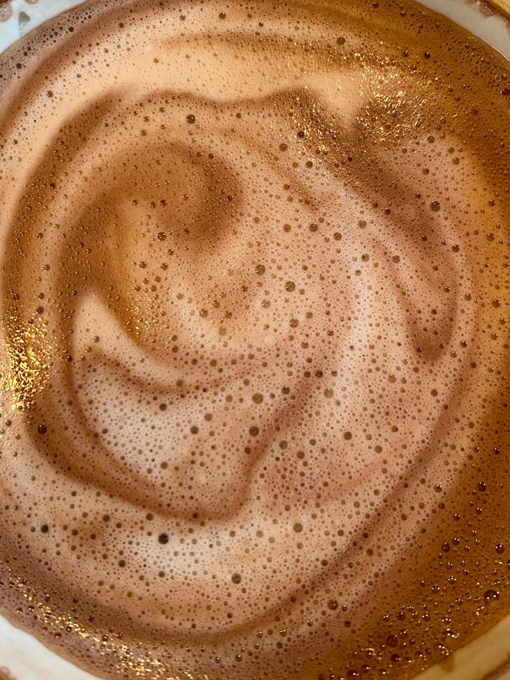 Top view of foamy coffee with swirling latte art