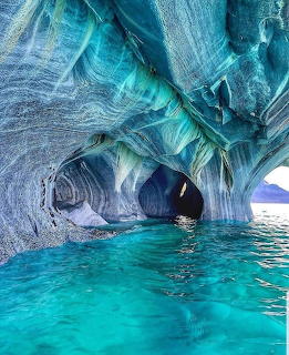 Blue and grey marble cave formations over turquoise water in Chile