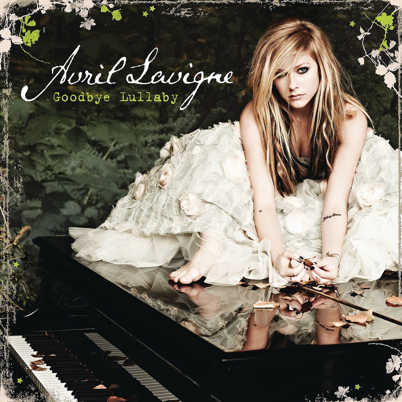 Avril Lavigne in a white dress sitting on a black grand piano with autumn leaves scattered around