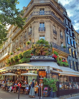 Corner café building in Paris with outdoor seating and classic Haussmann architecture