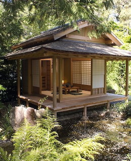 Traditional Japanese tea house with wooden deck and shoji screens surrounded by green garden