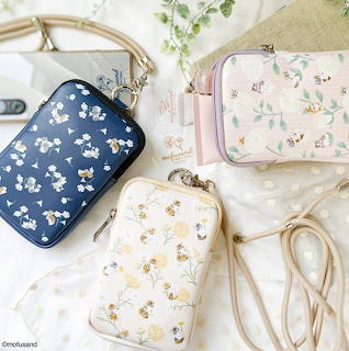 Three pastel crossbody bags with floral cat prints in a soft flat lay arrangement