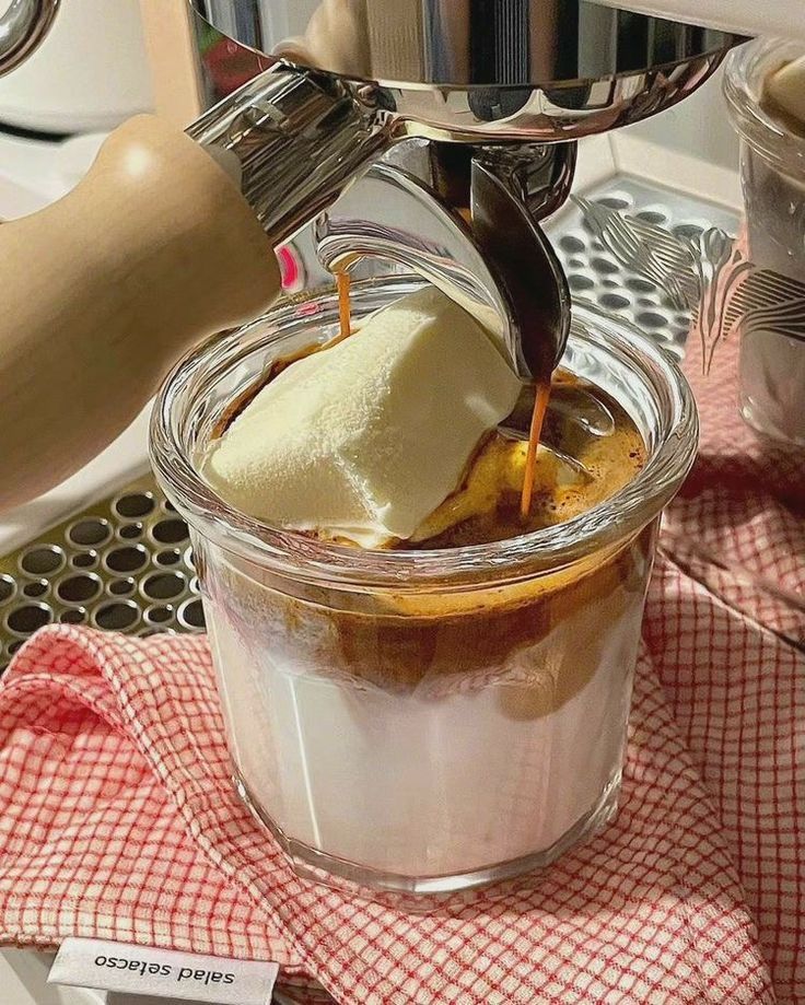 Espresso pouring over vanilla ice cream in a glass affogato dessert