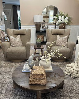 Cozy beige living room with two upholstered chairs and a round coffee table with neutral decor