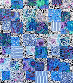 Colorful patchwork quilt with blue and purple fabric squares in various patterns
