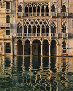 Painting of a Venetian palace facade above canal water with shimmering reflections