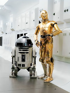 R2-D2 and C-3PO droids from Star Wars standing in white futuristic corridor
