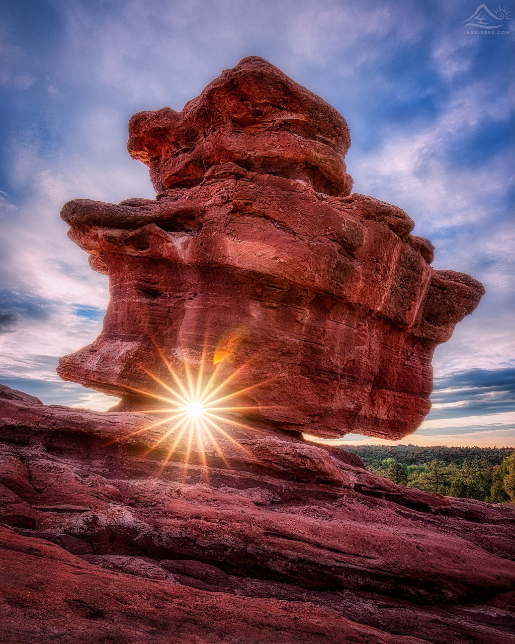 Red sandstone rock formation with sun star peeking through at Garden of the Gods, Colorado
