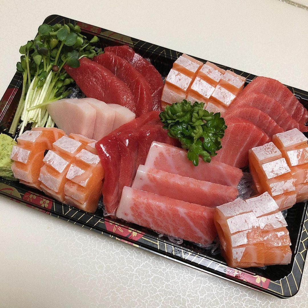 Assorted sashimi platter with sliced raw fish including tuna, salmon, and garnishes