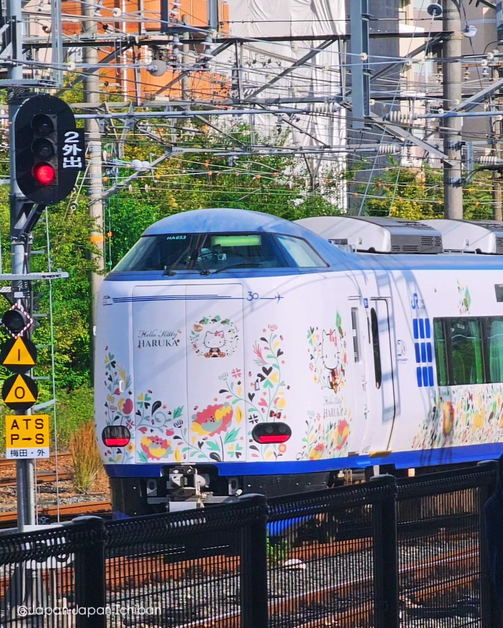 Pink Hello Kitty Haruka express train at a Japanese station platform
