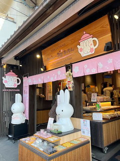 Miffy cafe storefront in Arashiyama Japan with white rabbit statues and pink teapot sign