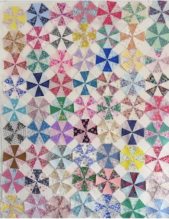 Colorful patchwork quilt with pinwheel star blocks in rainbow colors