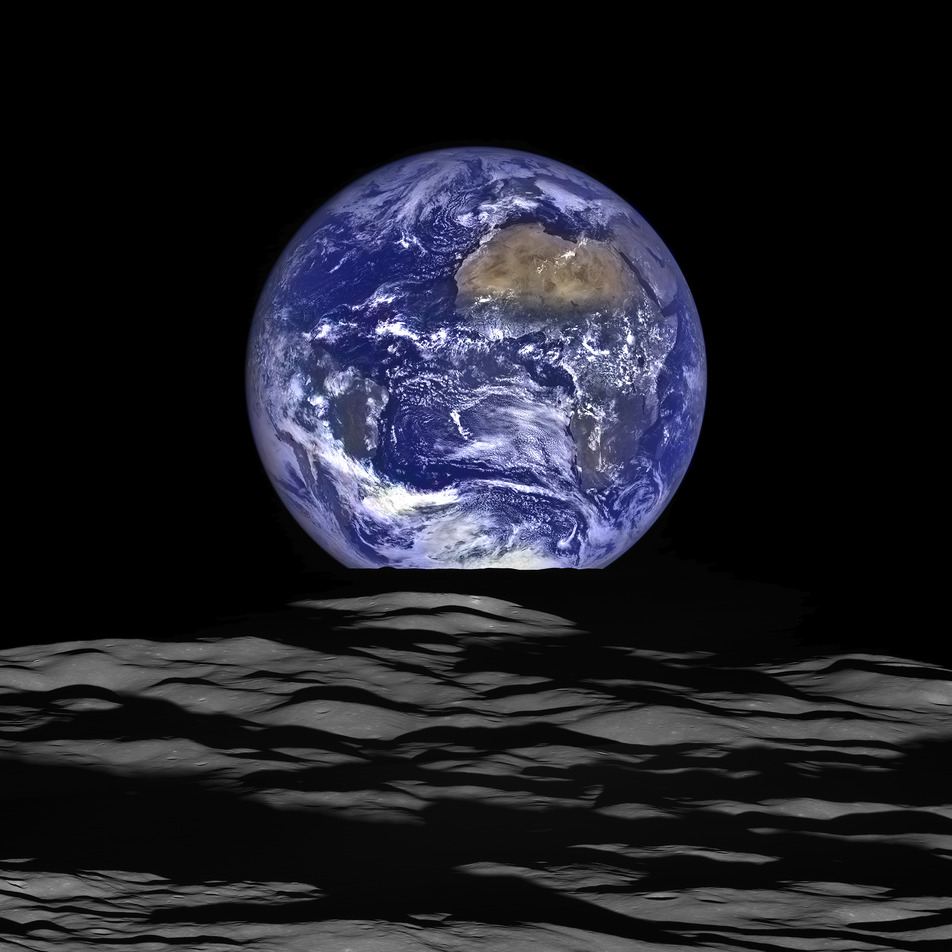 Earth rising above the Moon's gray surface against a black sky