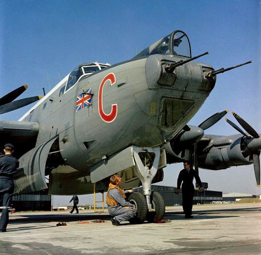 Front view of an Avro Shackleton aircraft on a tarmac with a few people nearby