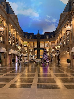 Lavish indoor shopping arcade with European architecture, painted ceiling, and illuminated Christmas tree