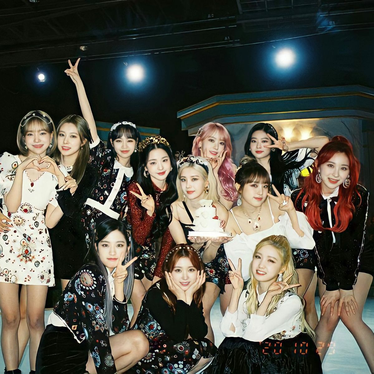 Large group of young women in fashionable outfits posing together under stage lights