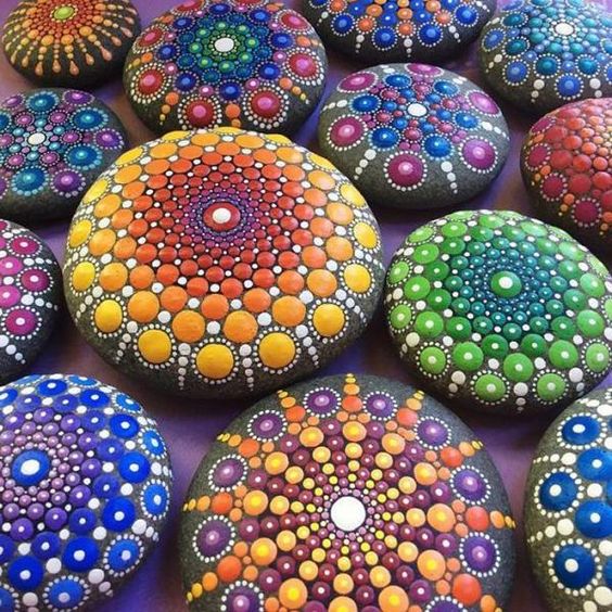 Colorful stones painted with intricate mandala dot patterns in various colors