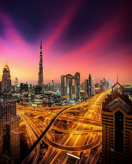 Dubai skyline with Burj Khalifa and illuminated highway interchanges at sunset