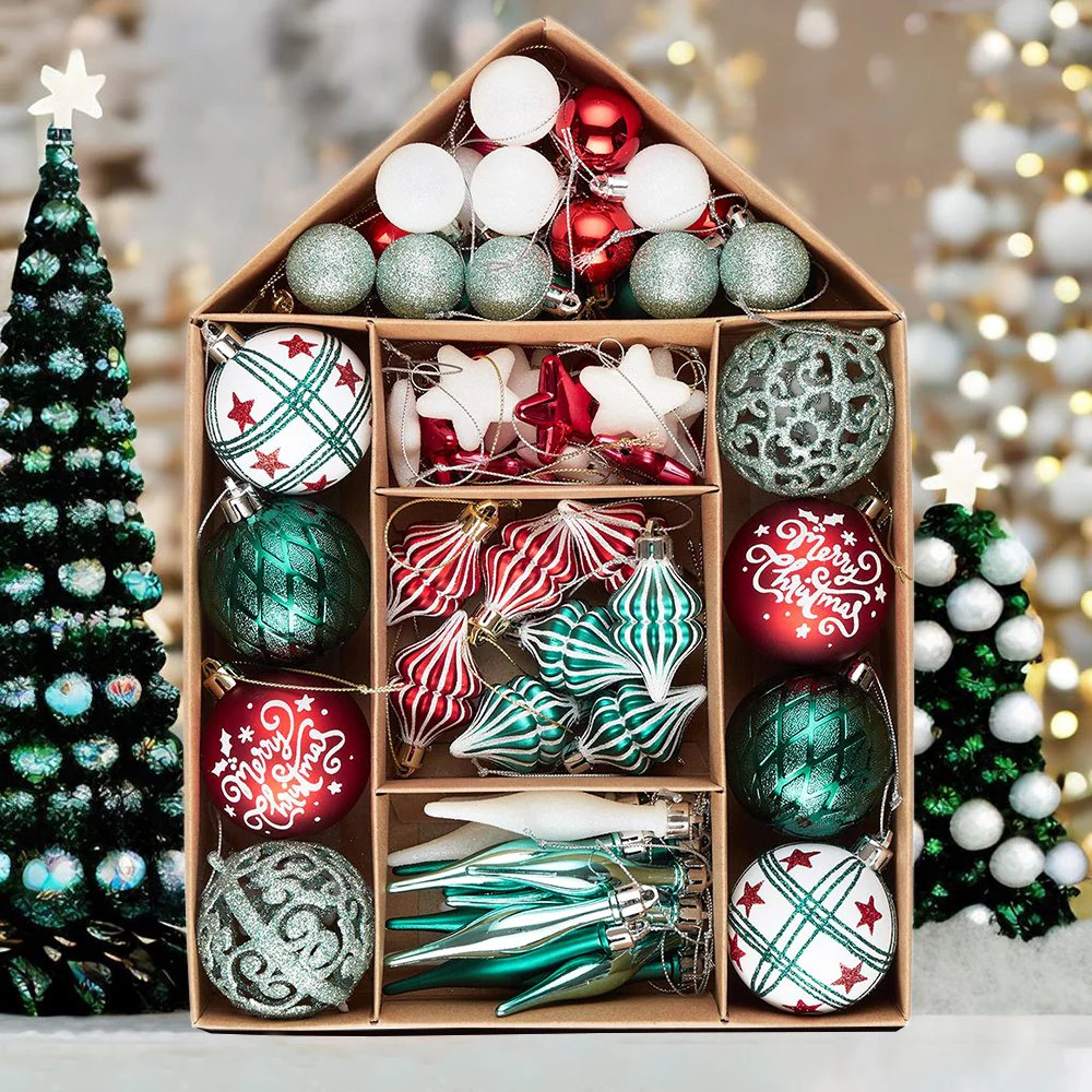 Wooden compartment box displaying assorted Christmas ornaments in festive colors with small decorated trees on sides