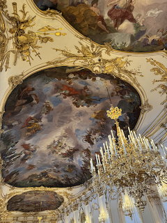 Baroque ceiling fresco with gold stucco ornaments and crystal chandelier at Schönbrunn Palace, Vienna