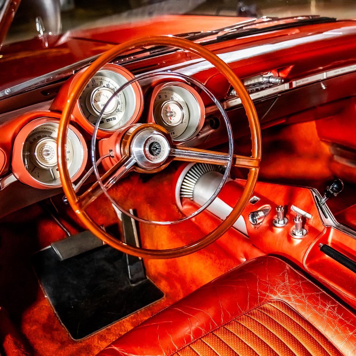 Red leather interior of 1963 Chrysler Turbine with chrome steering wheel and dashboard