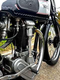 Close-up of vintage Norton motorcycle engine with chrome fuel tank and mechanical details