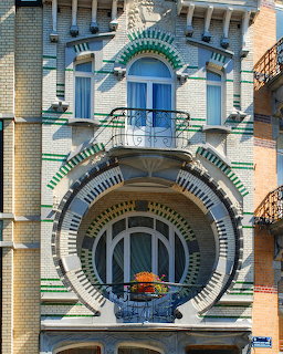 Art Nouveau townhouse facade with circular arched windows and colorful decorative tilework