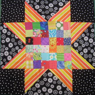 Colorful patchwork quilt with a striped star and patterned fabric squares